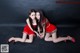 A couple of women in red dresses posing for a picture.