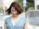 A woman in a blue dress is walking down the street.